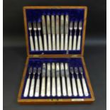 A set of twelve Edwardian silver bladed fruit of dessert knives and forks, all with carved mother of