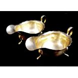 A pair of George V silver sauce boats, of conventional form with shaped rims and three applied feet,