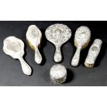 A group of six Victorian and Edwardian silver backed dressing table items, comprising a silver