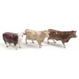A group of three Beswick cows, comprising a 'Hereford Cow "Ch. of Champions"', model 1360, brown and