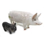 A group of two pig figurines, comprising a Royal Doulton 'Vietnamese Pot-Bellied Piglet', model