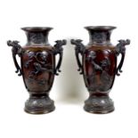 A pair of large Japanese bronze twin handled vases, Meiji period, decorated in high relief with