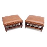 A pair of Aesthetic period mahogany footstools, with brown leather overstuffed seats, 32 by 26 by