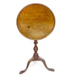 A George III mahogany occasional table, the tilt top dished circular surface with moulded rim,