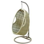 A modern garden egg shaped swing seat, wicker effect plastic, with metal support frame.