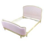 A modern double bed frame, in French 19th century style, with pink and white striped fabric head and