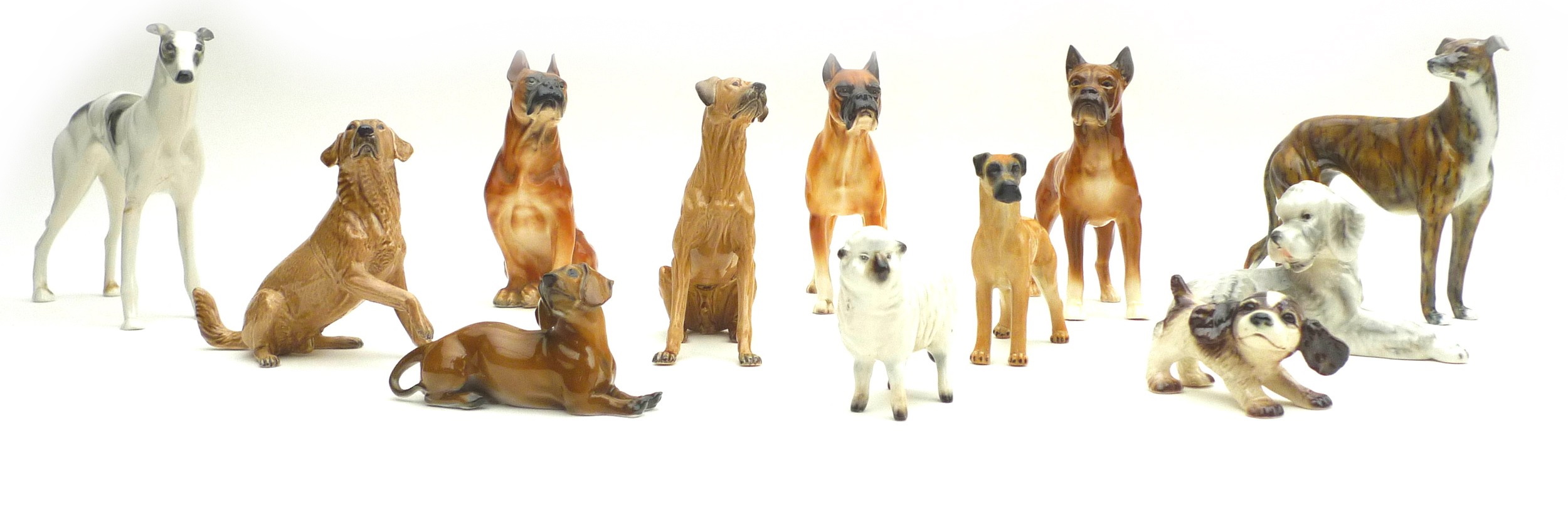 A collection of ceramic animal figurines, all modelled as dogs, some marked, including two Goebel,