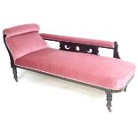 A Victorian chaise longue, with an ebonised frame, fucia upholstery, raised upon turned legs with
