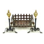 A Victorian cast iron fire place with fire dogs, both topped with polished brass finials, basket
