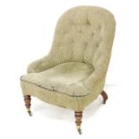 A Victorian tub armchair, with button back pale green textured fabric, turned front legs and brass