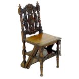 An oak metamorphic chair, in Jacobean style with carved decoration and turned legs, the hinged