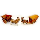 Two ceramic figurines, modelled as horses, one pulling a wooden cart, the other a caravan,