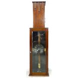 A mid 20th century oak cased electric clock, a/f not in working condition, with silvered dial signed