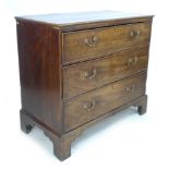 A George III mahogany chest of three graduating drawers, with brass swan neck handles, raised on