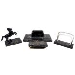 A set of black marble desk items, comprising an inkwell, 28cm across, a letter rack, a blotter,