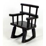 A Folk Art treen carved wooden miniature rocking chair, possibly made for a teddy bear or a doll,
