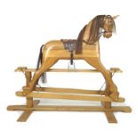 A modern pine carved rocking horse, late 20th century, with brown leather saddle, on a varnished