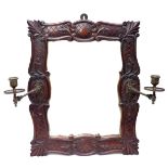 An Edwardian wall mirror, rectangular plate, with hinged brass candle sconces, lattice carved detail