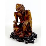 A Chinese carved wooden sculpture, late 19th / early 20th century, modelled as a mendicant, seated