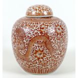A Chinese ginger jar and cover, decorated in iron red with a dragon flying amongst a scrolling