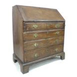 A George III oak bureau, fall front with fitted interior, four graduating drawers with brass
