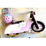 A KiddiMoto children's wooden balance bike, in the form of a pink and white 'Vespa' style moped,