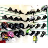 A group of fourteen helmets, various sizes and colours, together with thiry two slatwall mounting