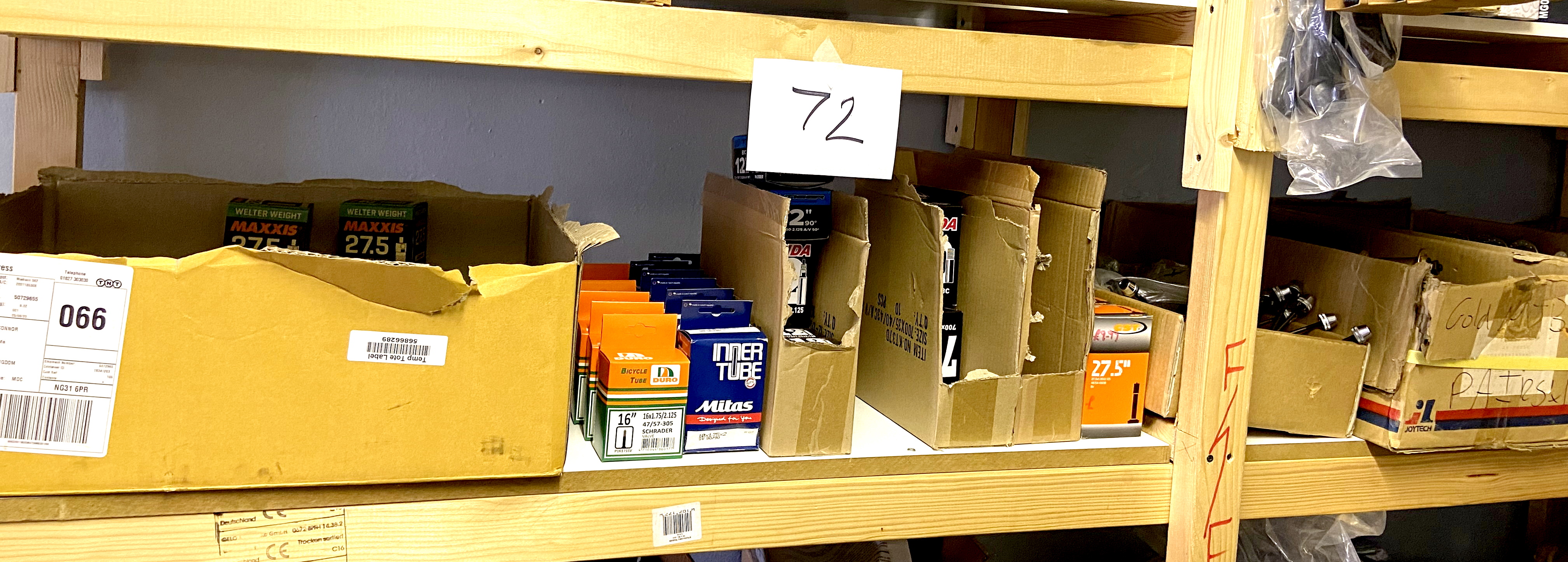 A quantity of boxed bike parts and accessories, including inner tubes, valves, and wheel hubs. (