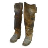 A pair of early 20th century thigh high black leather farm boots, with metal studded soles and