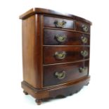 A miniature bow fronted chest of drawers, mahogany, two over three drawers with brass handles, 40 by