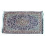 A large rug with blue ground, central salmon coloured lozenge with blue flower design to center,