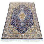 A Turkish rug, dark blue floral field, pale blue and cream corners, 188 by 120cm.