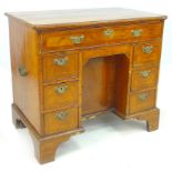 An 18th century walnut kneehole desk, the moulded edge upper surface with incuse front corners and