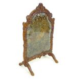 A French 18th century carved wooden fire screen, the frame decorated with Rococo foliate scrolls,