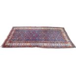 A Caucasian rug with dark blue ground and flat weave ends, floral field, red and white borders,