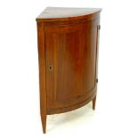An Italian early 20th century walnut corner cupboard, bow fronted with single door enclosing two