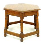 An early 20th century oak occasional table, with hexagonal surface, line carved decoration, pegged