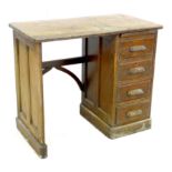 An early 20th century oak desk, with a bank of four drawers and carved handles, 81 by 45.5 by 68.5cm