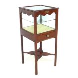 An Edwardian mahogany vitrine, with hinged glazed cover enclosing a deep display space with glass