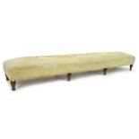 A 19th century long footstool, the overstuffed 'seat' upholstered in cream velvet centred along