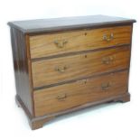 A George III mahogany chest of three graduating drawers, with brass swan neck handles, raised on