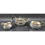 An Edward VII silver three piece tea service, of London shape, comprising teapot with ebonised