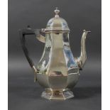 A George V silver coffee pot, of octagonal form with ebonised handle and stepped base,