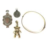 A small group of jewellery, comprising a yellow metal articulated bear charm with white stone