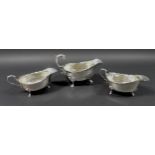 Three Edwardian silver sauce boats, the largest with scroll hand raised upon three claw feet with