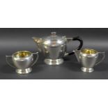 An Art Deco Indian Colonial silver three piece tea set, by Warner Bros, comprising teapot with