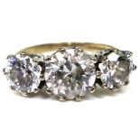 A 9ct gold three stone ring, the three large cubic zirconias brilliant cut, scroll setting, the band
