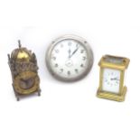 A group of three clocks, including a small brass carriage clock with key, a brass cased lantern