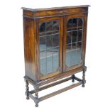 A 1930s oak bookcase, twin leaded glazed doors enclosing two adjustable shelves, 91 by 26.5 by 122cm