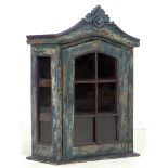 A small 20th century shabby chic wall hanging display cabinet, with shaped cornice and single door